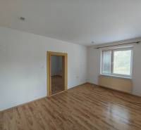 Prechodszimmer mit Holzboden und Fenster in einem Einfamilienhaus.