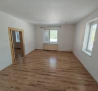 Ein Zimmer in einem Einfamilienhaus mit Holzboden und weißen Wänden.