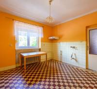 Eine Küche mit orangefarbenen Wänden und einem Schachbrettboden in einem Einfamilienhaus.