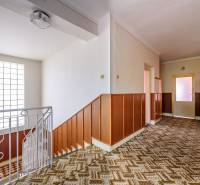 Flur in einem Einfamilienhaus mit Holzverkleidung und gemustertem Teppich.