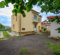 Ein Einfamilienhaus in Vidiná mit Garten, Rasen und umliegenden Gebäuden.