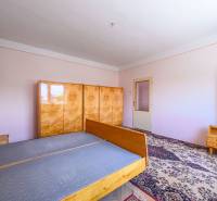 Schlafzimmer in einem Einfamilienhaus mit Holzmöbeln und Teppichboden.