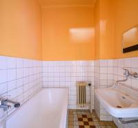 Badezimmer in einem Einfamilienhaus mit Badewanne, Waschbecken und Wandfliesen.
