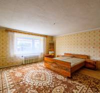 Schlafzimmer mit Bett, gemusterten Tapeten und Teppichen in einem Einfamilienhaus.