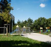 Ein Kinderspielplatz umgeben von Grünflächen und Plattenbauten, Košice - Stadtteil Juh.