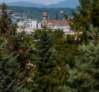 Panorama von Košice mit Blick auf historische Gebäude, umgeben von Grünflächen und Bergen im Hintergrund.