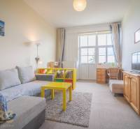 Wohnzimmer mit hellem Sofa und gelbem Tisch in einer 3-Zimmer-Wohnung.