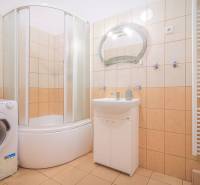 Badezimmer in einer 3-Zimmer-Wohnung mit Dusche, Waschmaschine und Waschbecken.