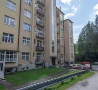 Ein fünfstöckiges Wohngebäude in der Hohen Tatra mit Zufahrtsstraße und Parkmöglichkeiten.