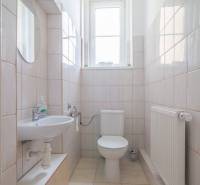 Badezimmer in einer 3-Zimmer-Wohnung mit Waschbecken, Toilette, Heizkörper und Fenster.