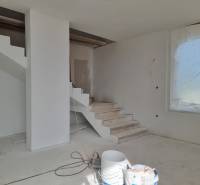 Die Treppe in der Villa während der Renovierung, neben einem großen Fenster mit verdeckter Aussicht.