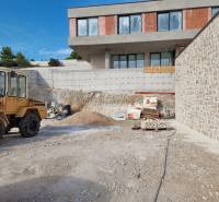 Baustelle mit einer im Bau befindlichen Villa in der Stadt Vodice, sichtbar sind eine Baumaschine und Material.