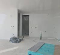 Ein unfertiger Raum in einer Villa mit weißen Wänden und einem unvollendeten Boden.