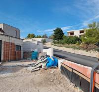 Baufläche bei der Villa in Vodice mit Straße und umliegendem Grün.