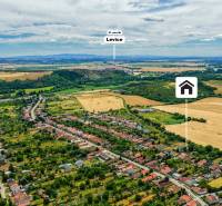 Luftaufnahme eines Einfamilienhauses in Kozárovce, umgeben von landwirtschaftlicher Landschaft und Grünflächen.