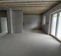 Geräumiges Interieur eines Familienhauses mit Betonboden und Holzdecke.