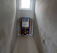 Toilette in einem Einfamilienhaus mit Fenster und installiertem WC-System.