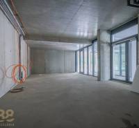 Innenraum von Geschäftsräumen mit Glaswand, Betondecke und Elektroinstallation.