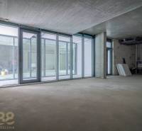 Unvollendete Geschäftsräume mit verglasten Wänden und Betondecke.