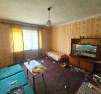 Wohnzimmer in einem Einfamilienhaus mit Sofa, Tapetenwand und Möbeln.