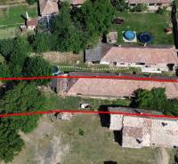 Ein Einfamilienhaus in Hronovce mit einem Grundstück, das von Grünflächen und benachbarten Gebäuden umgeben ist.