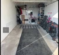 Die Garage enthält Fahrräder, Kinderwagen und Regale mit Stauraum.