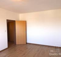 Ein Zimmer in einer Einzimmerwohnung mit Holzboden und offener Tür.