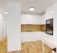 Küche in einer 2-Zimmer-Wohnung mit Holzboden und eingebauten Geräten.