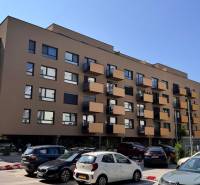 Wohnhaus in der Sadová-Straße in Senica mit geparkten Autos und Balkonen.