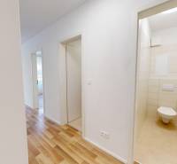Flur mit Eingang zur Toilette in einer 2-Zimmer-Wohnung mit Holzboden.