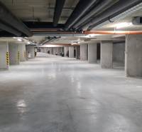 Unterirdische Garage mit Parkplätzen und Betonpfeilern in einer Einzimmerwohnung.