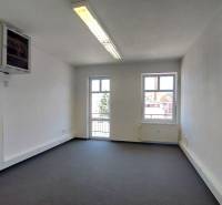 Ein geräumiges Büro mit Fenstern, einer hellen Decke und Steckdosen, ideal für produktive Arbeit.