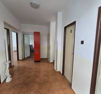 Der Flur im Einfamilienhaus mit braunem Boden, roter Schrank, weiße Wände.