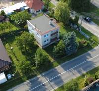 Ein Einfamilienhaus in Rakoľuby in Nové Mesto nad Váhom, umgeben von Grünflächen und einer Straße.