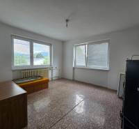 Einfaches Zimmer in einem Einfamilienhaus mit Blick durch große Fenster.