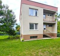 Ein Einfamilienhaus in Nové Mesto nad Váhom mit Garten und Bäumen auf einer Rasenfläche.