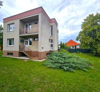 Ein zweistöckiges Einfamilienhaus in Nové Mesto nad Váhom mit Rasen und Baum.