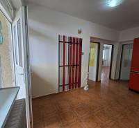 Innenraum eines Einfamilienhauses mit einem zu öffnenden Fenster, Türen, Kleiderhaken und Fliesen.