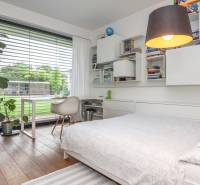 Schlafzimmer in einem Einfamilienhaus mit Bett, Regalen und einem großen Fenster mit Aussicht.