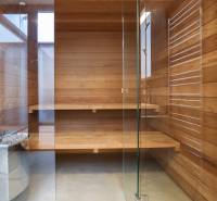 Holzsauna mit Glastüren und Bänken im Einfamilienhaus.