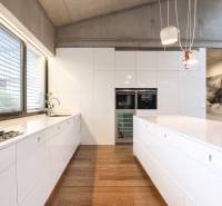 Küche in einem Einfamilienhaus mit weißen Schränken und Holzboden.