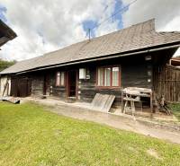 Eine Holzhütte in Papradno mit grasbewachsener Umgebung und einem Holzzaun.