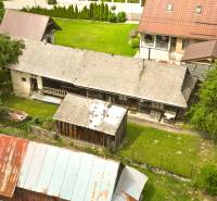 Eine rustikale Hütte in Papradno, umgeben von Grün und Nebengebäuden.