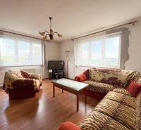 Wohnzimmer eines Einfamilienhauses mit Sofas, Fernseher und Tisch, helle Atmosphäre.