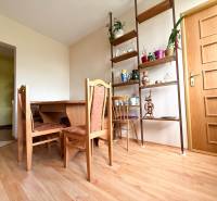 Esszimmer in einem Einfamilienhaus mit Holztisch, Stühlen und dekorativen Regalen.