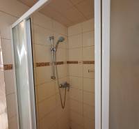 Duschkabine in einem Einfamilienhaus mit Keramikfliesen und verstellbarem Duschkopf.