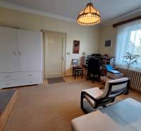 Wohnzimmer in einem Einfamilienhaus mit Sessel, Schreibtisch und Kommode.