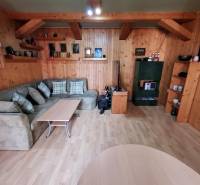 Gemütliches Wohnzimmer mit Holzverkleidung, Sofa und Tisch in einem Einfamilienhaus.