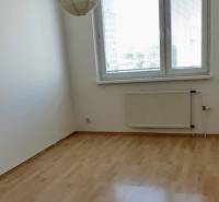 Ein leerer Raum mit Holzboden, Heizkörper und Fenster in einer 3-Zimmer-Wohnung.