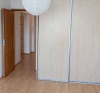 Ein Zimmer in einer 3-Zimmer-Wohnung mit Holzböden und einem Schrank mit Schiebetüren.